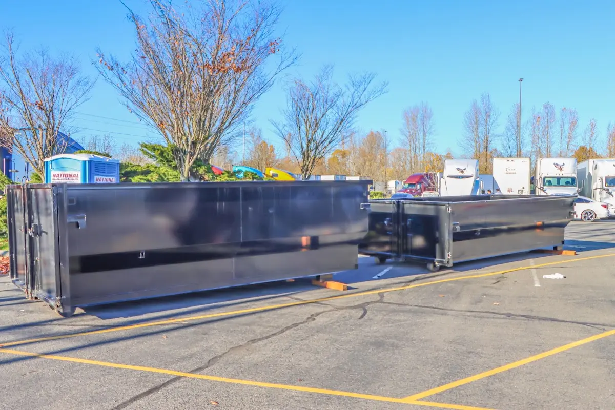 Professional dumpster rental service with roll-off container on residential driveway in Falls